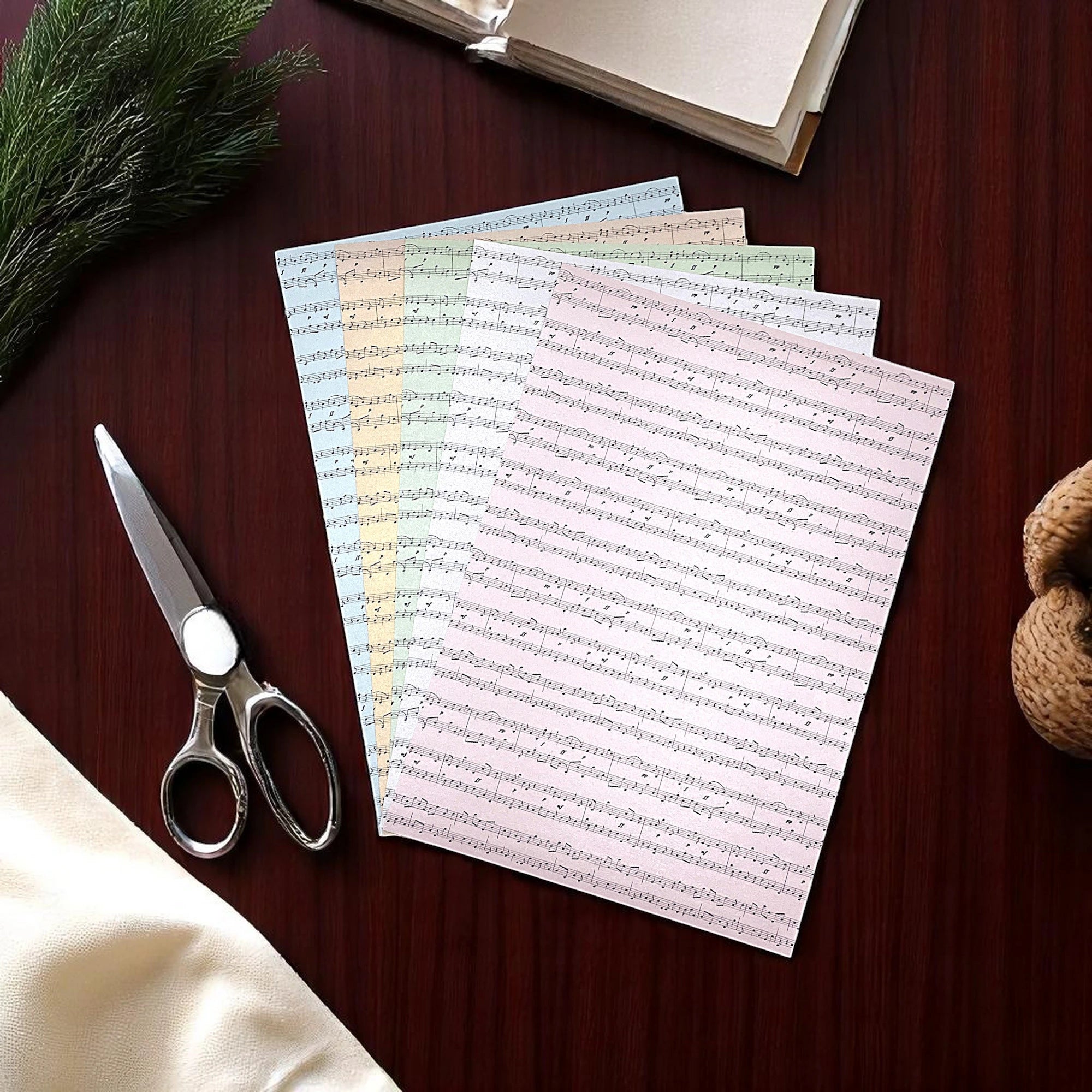 Auf einem Tisch liegen Notenblätter zum basteln für Scrapbooking