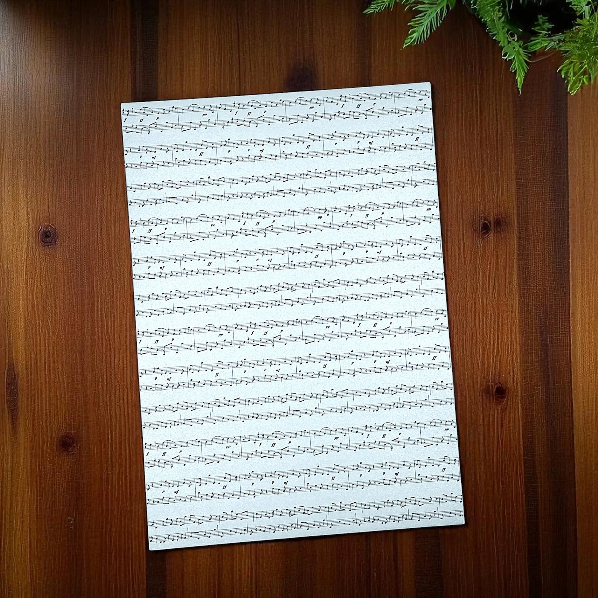 Papier mit Noten in der Farbe blau auf einem Holztisch