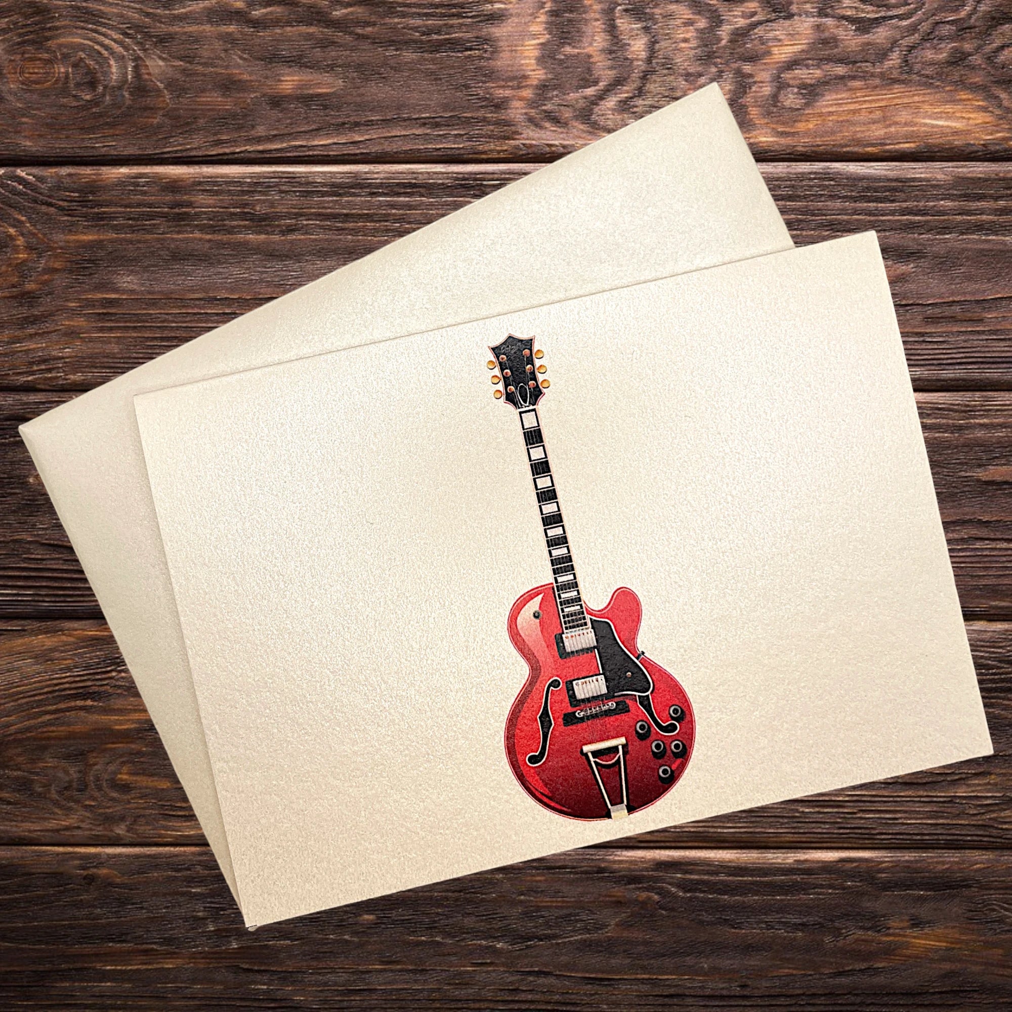 Musik-Klappkarte mit roter E-Gitarre, präsentiert auf rustikalem Holztisch