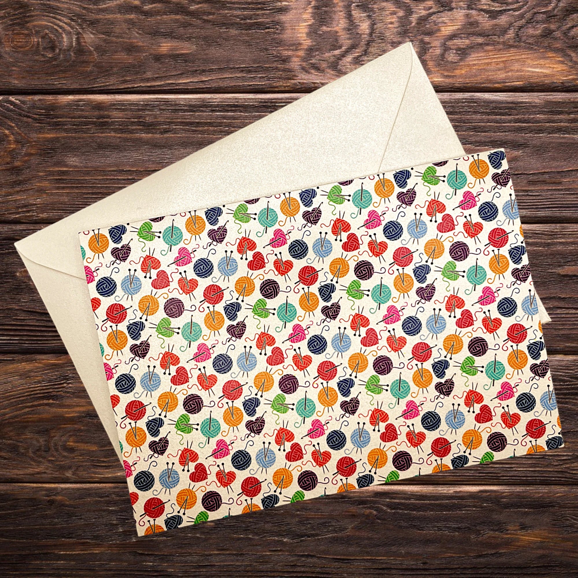 Handarbeits-Klappkarte mit Wolle und Stricknadeln, präsentiert auf rustikalem Holztisch