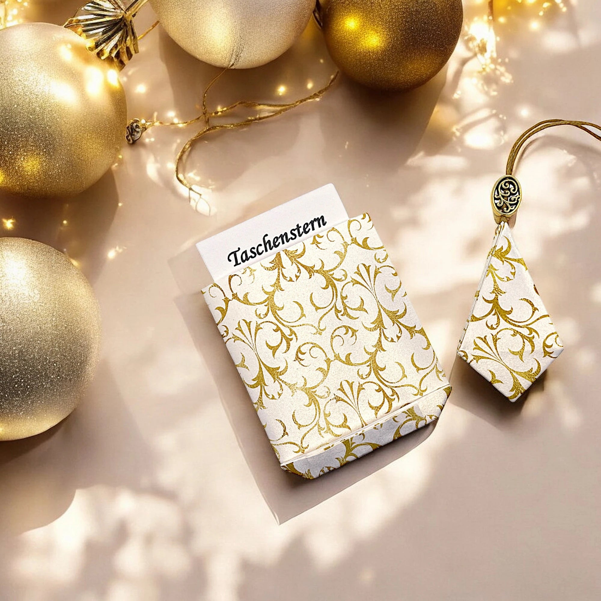 Geschlossener Papierstern Arabeske Gold-weiß mit Etui, dekoriert mit goldenen Kugeln.