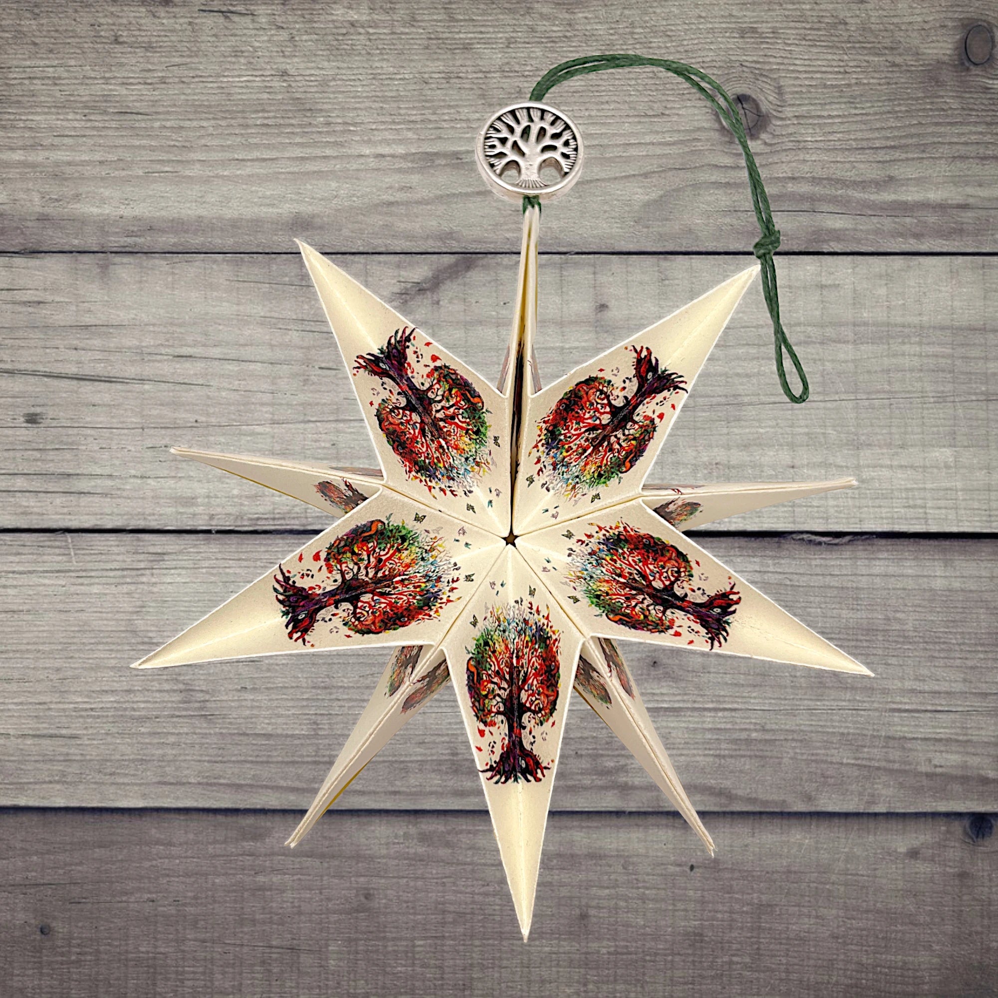 Papierstern mit buntem Baum des Lebens, dekorativ präsentiert auf rustikalem Holzhintergrund