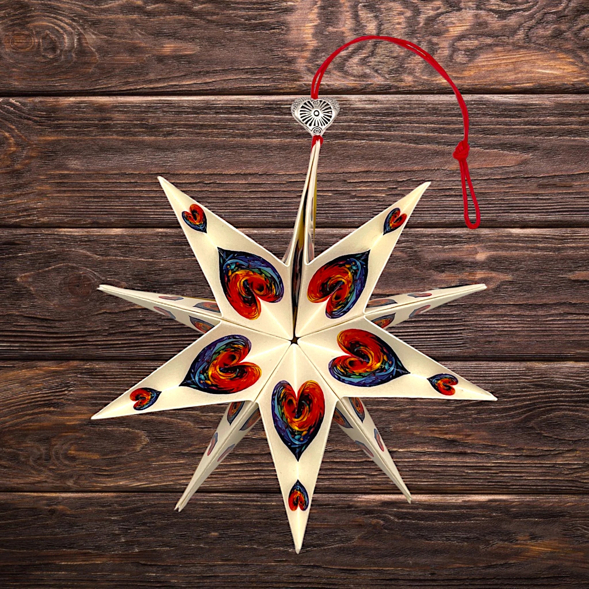 Papierstern mit buntem Herz-Design, liebevoll präsentiert auf rustikalem Holztisch