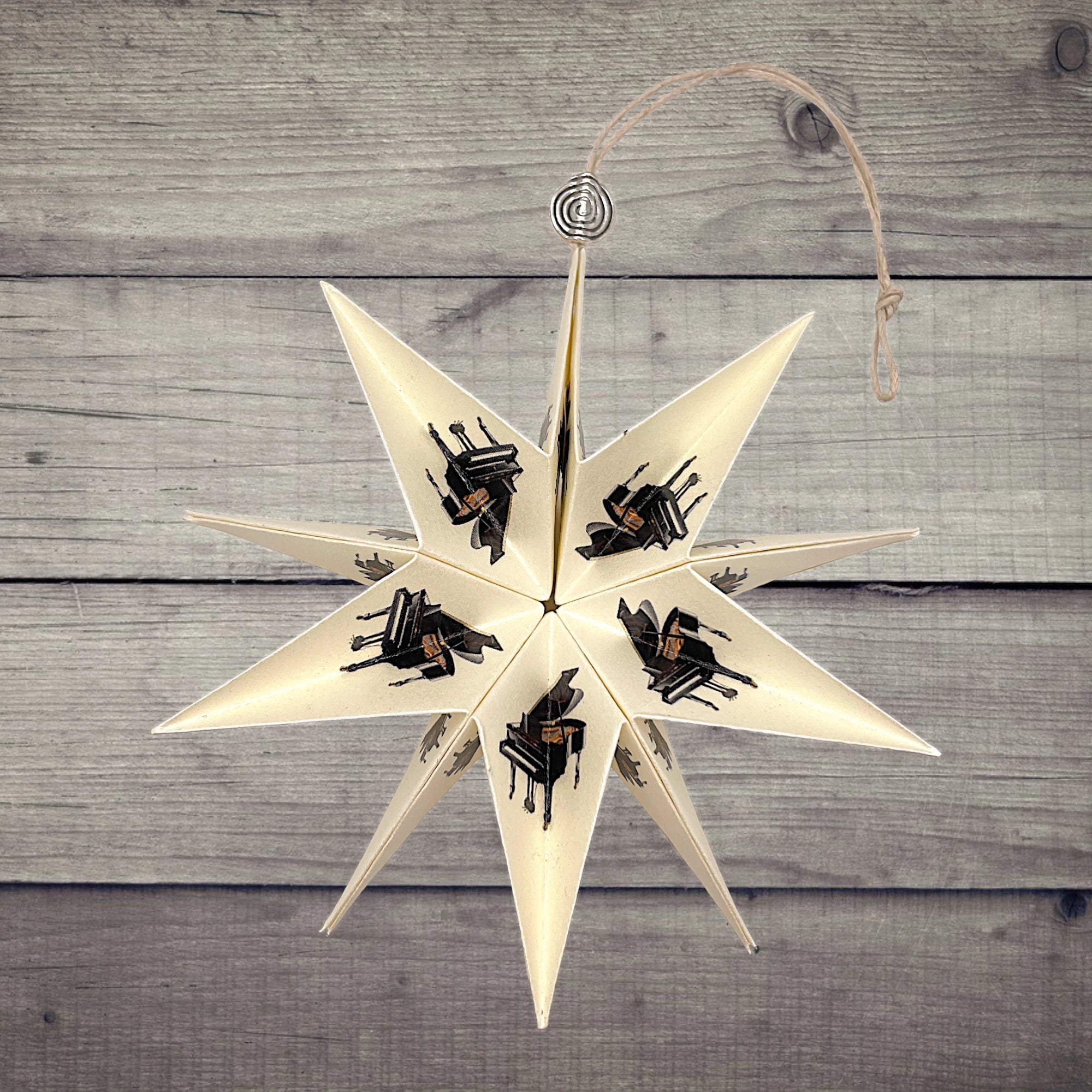 Papierstern mit elegantem Flügelmotiv, dekorativ auf Holztisch arrangiert