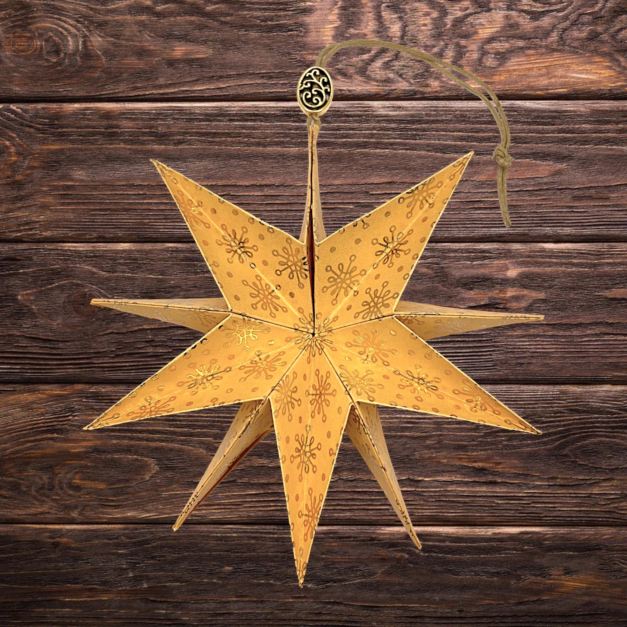 Goldverzierter Papierstern mit weihnachtlichem Motiv, dekorativ auf Holztisch arrangiert