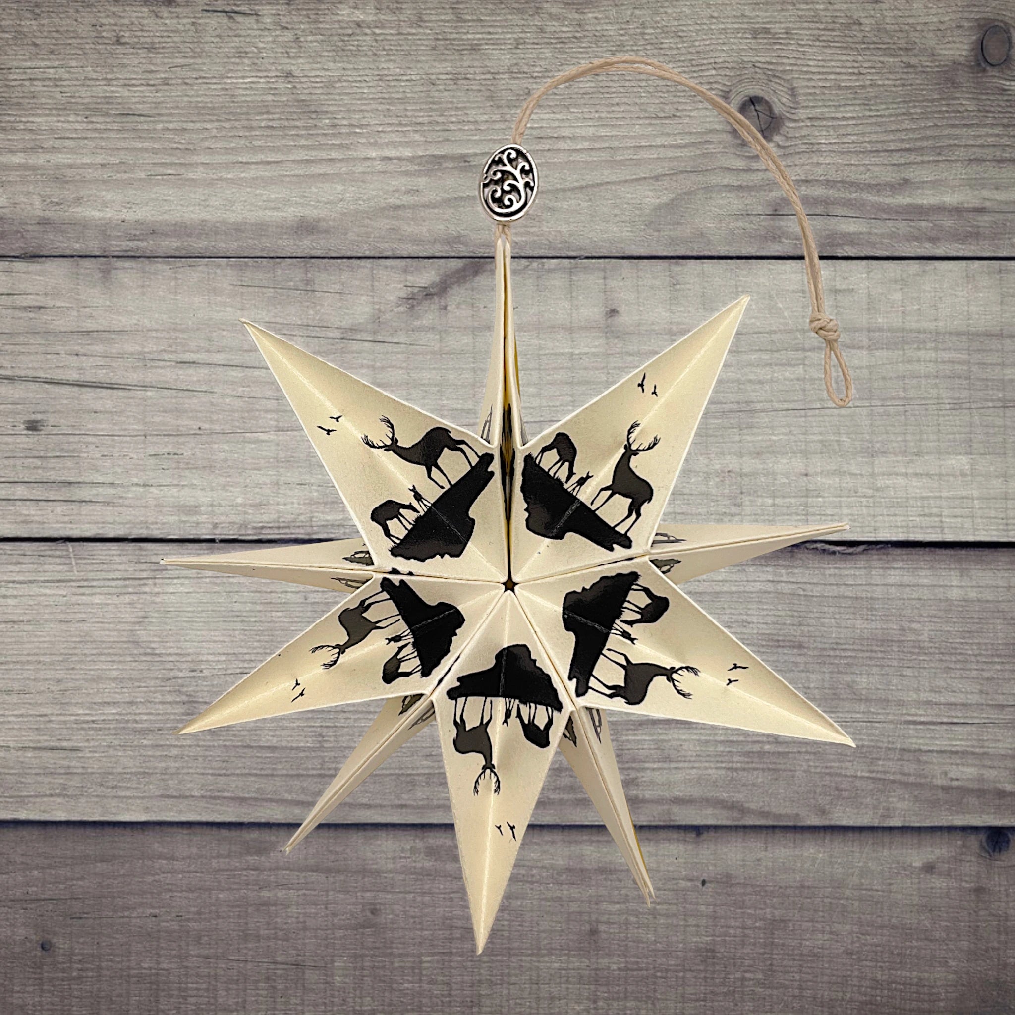 Papierstern mit Hirschmotiv, dekorativ präsentiert auf rustikalem Holzhintergrund