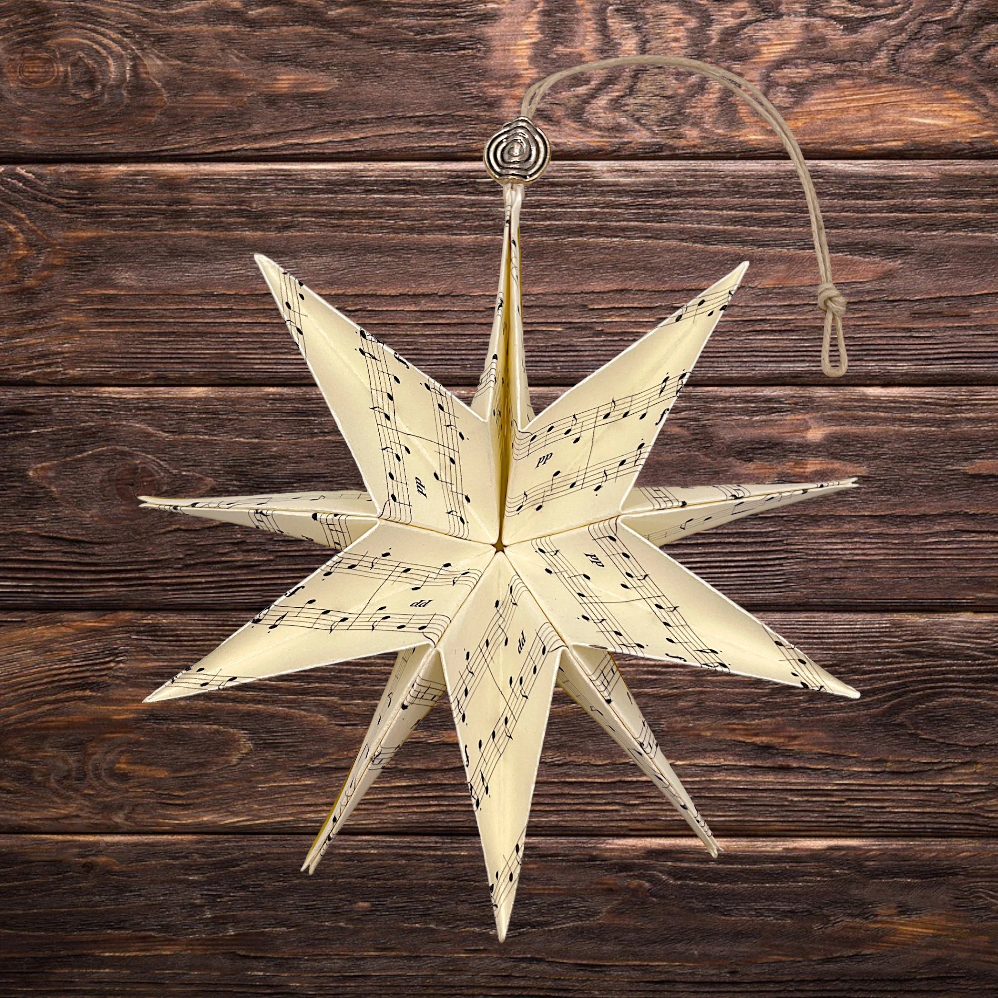 Klassischer Papierstern mit Musiknoten, dekorativ auf rustikalem Holz präsentiert