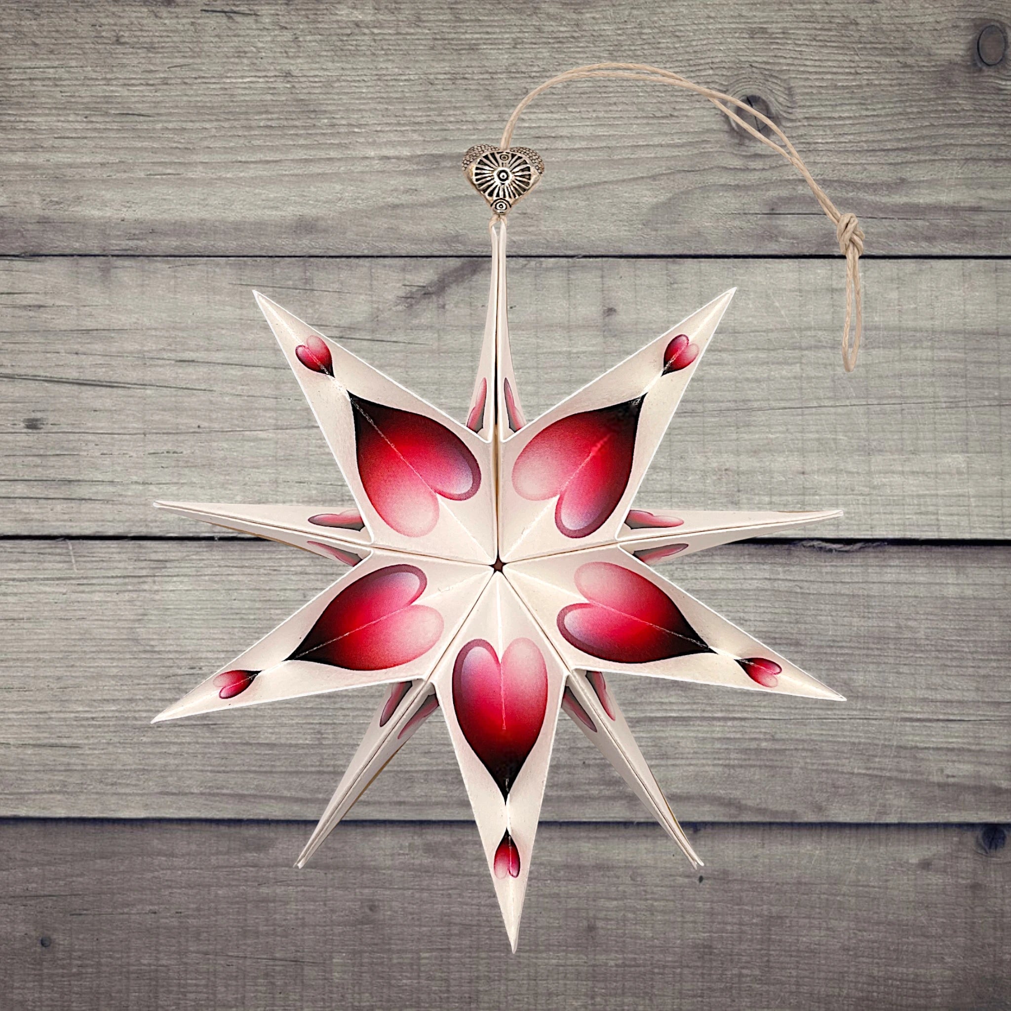 Papierstern mit rotem Herz als Deko auf rustikalem Holztisch – ideal zum Verschenken
