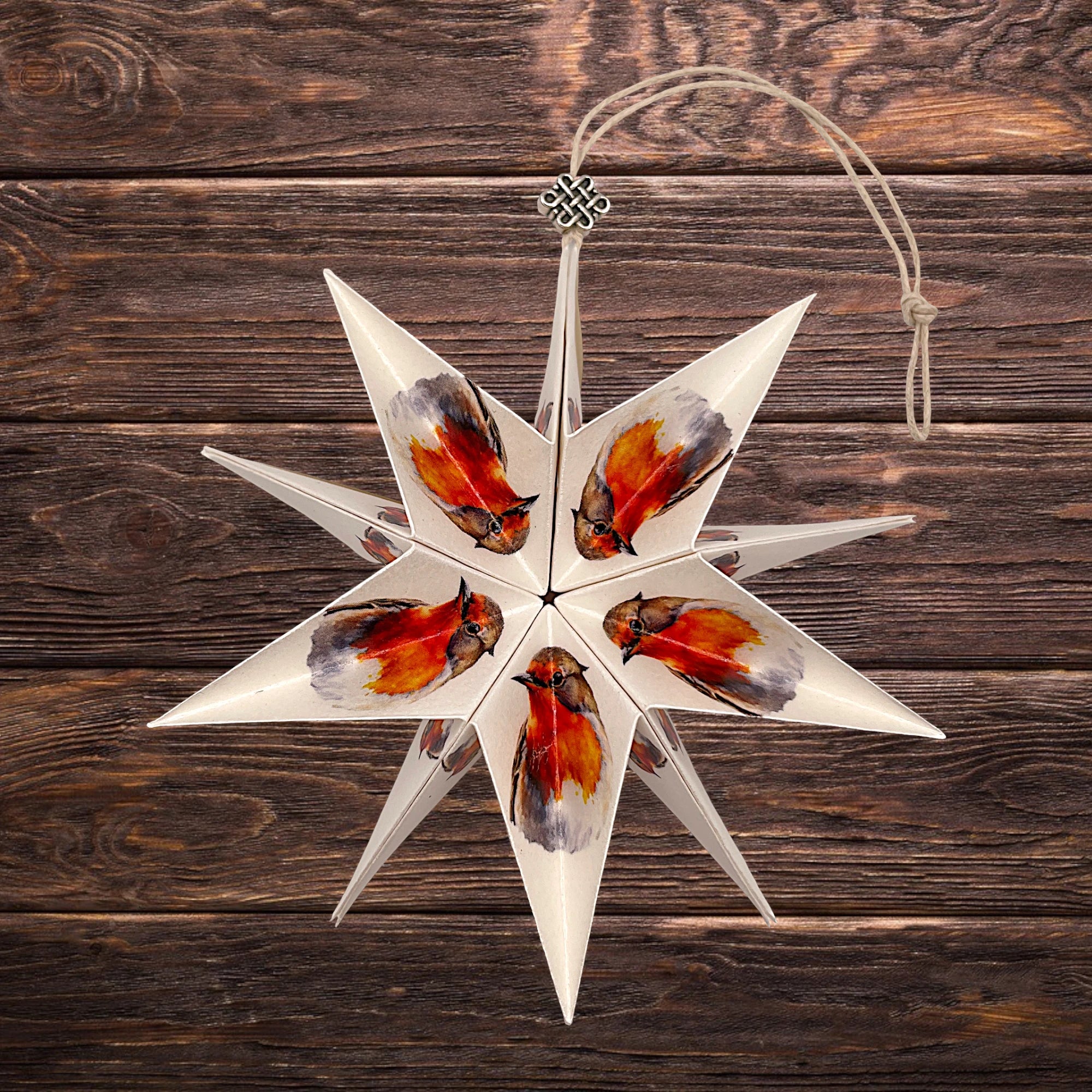 Papierstern Rotkehlchen, aufgeklappt vor rustikalem Holzhintergrund.