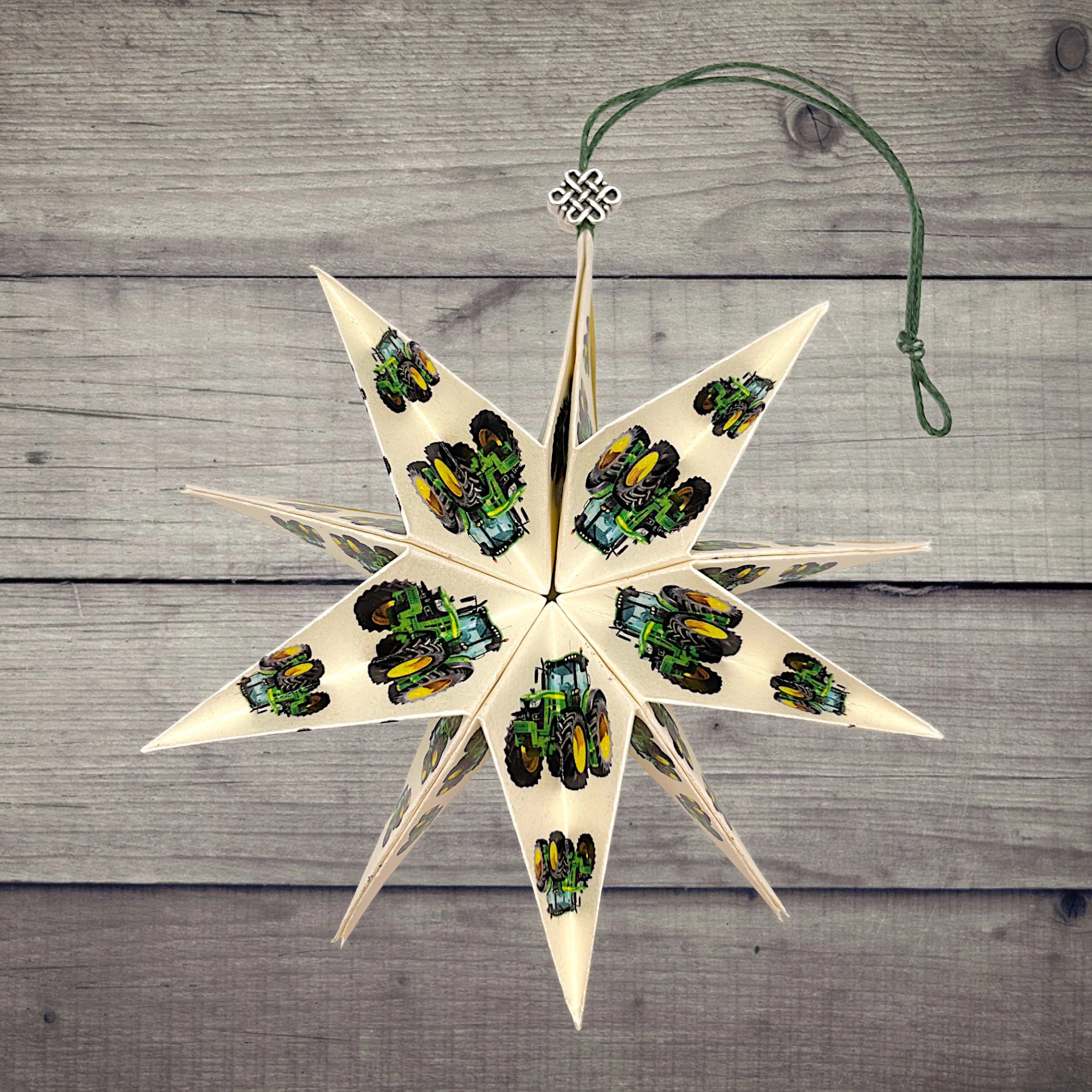 Papierstern mit Traktor in Grün, dekorativ arrangiert auf rustikalem Holztisch