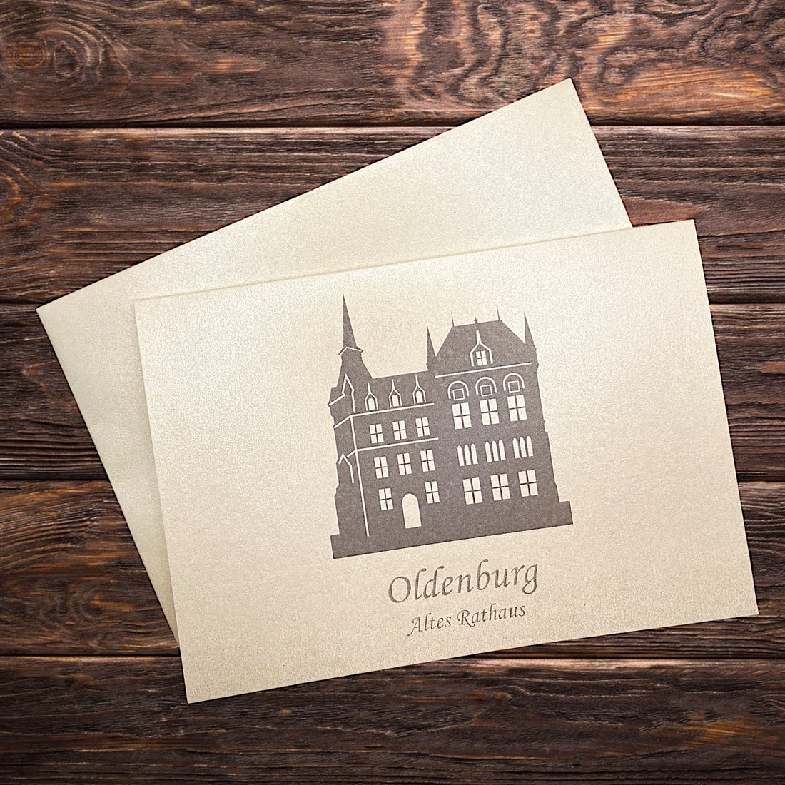 Auf einem Holztisch eine Klappkarte aus Oldenburg mit dem Alten Rathaus