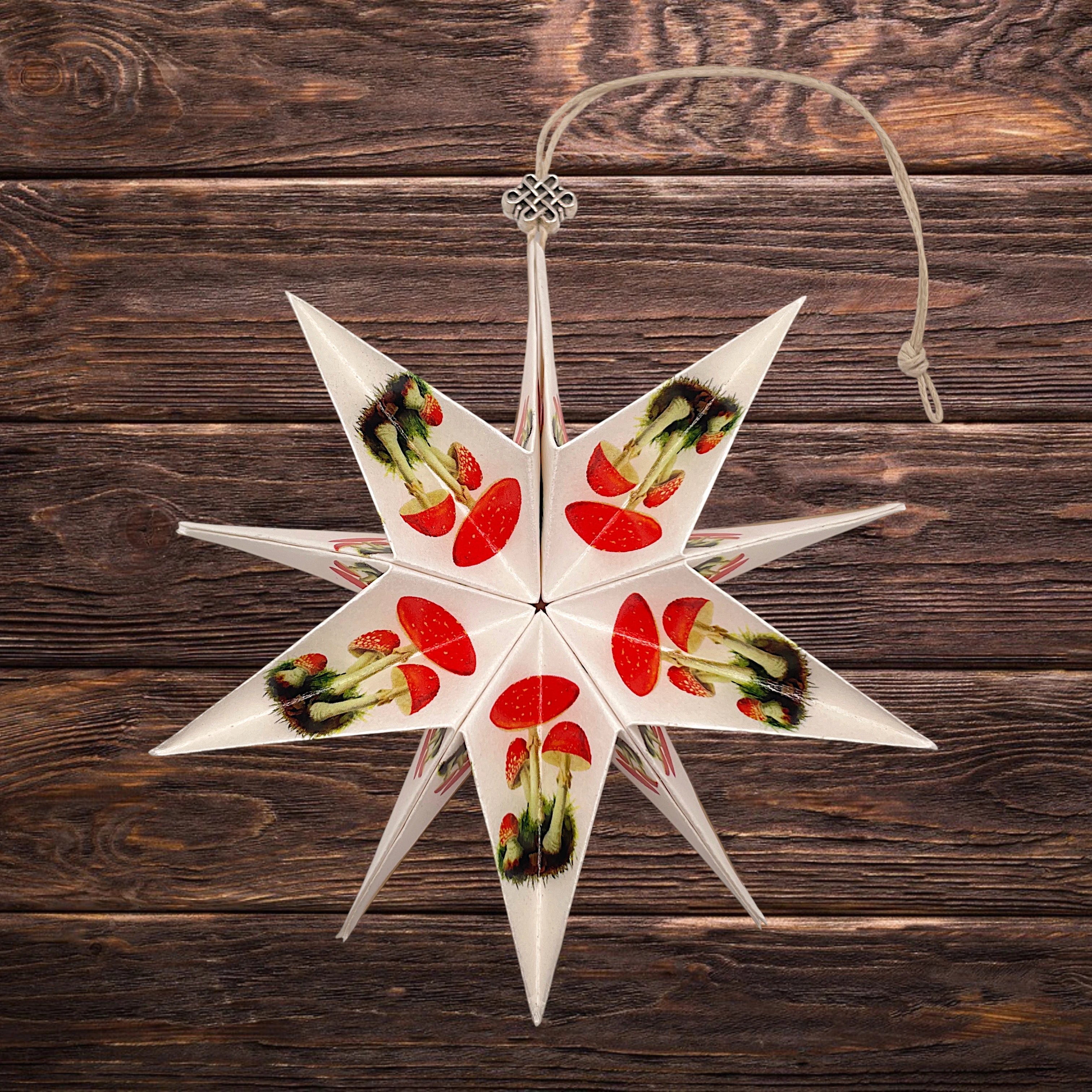 Dekorativer Papierstern mit Fliegenpilz-Motiv als Weihnachts- und Winterdekoration.
