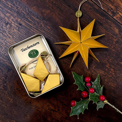 Detailaufnahme eines handgefertigten goldenen Papiersterns Mini aus hochwertigem Perlglanzpapier mit filigraner Falttechnik