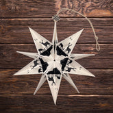 Handgefertigter Papierstern Hirschfamilie vor Holzwand – dekorativer Faltstern für Weihnachten und die Winterzeit.