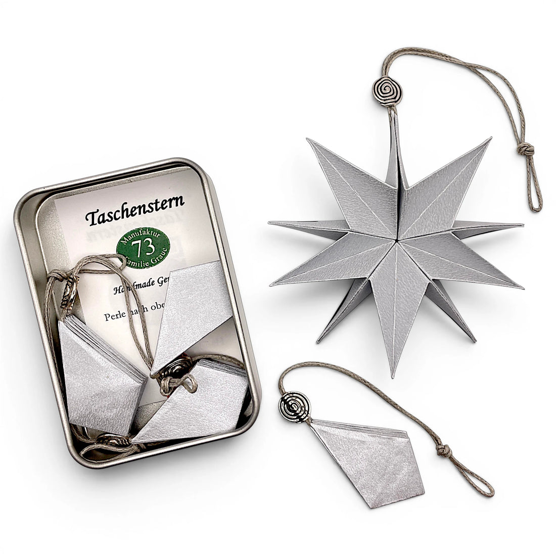 Papierstern Mini in Silber zusammengefaltet im Etui – dekorativer Faltstern für unterwegs.