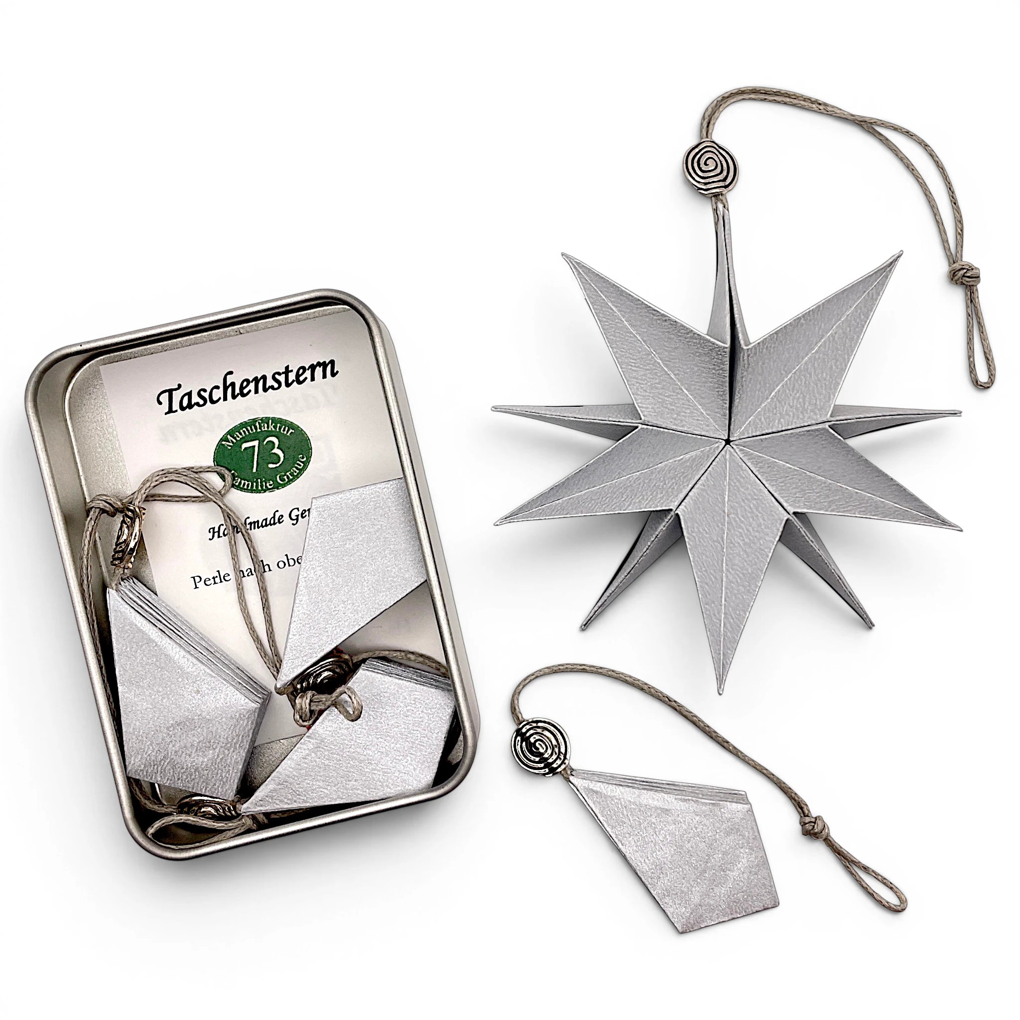 Papierstern Mini in Silber zusammengefaltet im Etui – dekorativer Faltstern für unterwegs.
