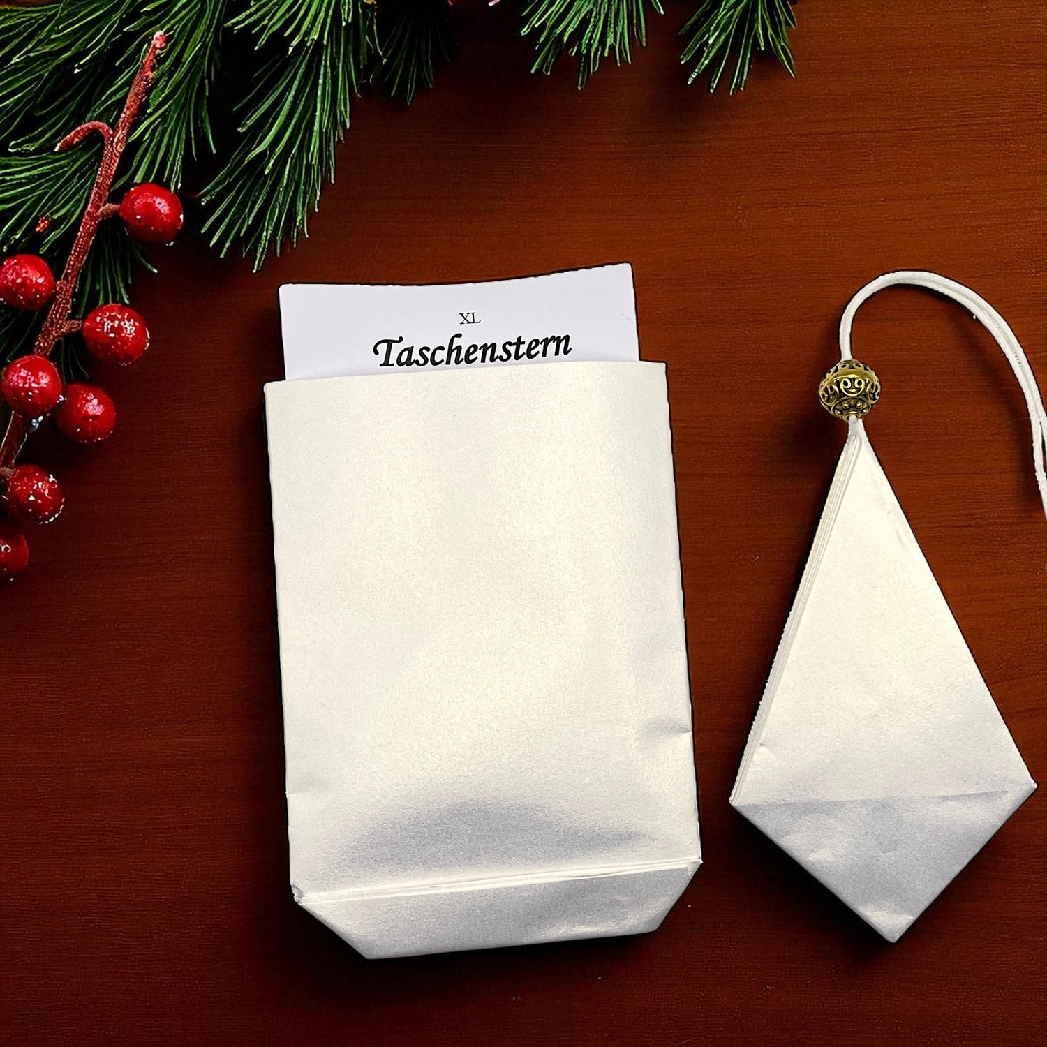 Liegend auf einem Tisch in einem Etui ein Papierstern in weiss mit gold